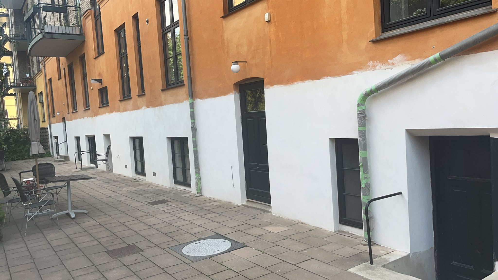 Nykalket facade og sokkel set fra gårdmiljø under facaderenovering