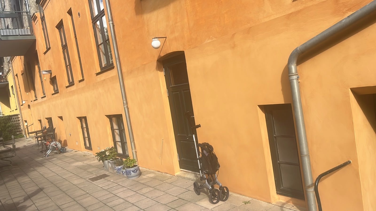 Kalkning af hus, færdigt resultat på gårdfacade med nedløb og kældernedgang